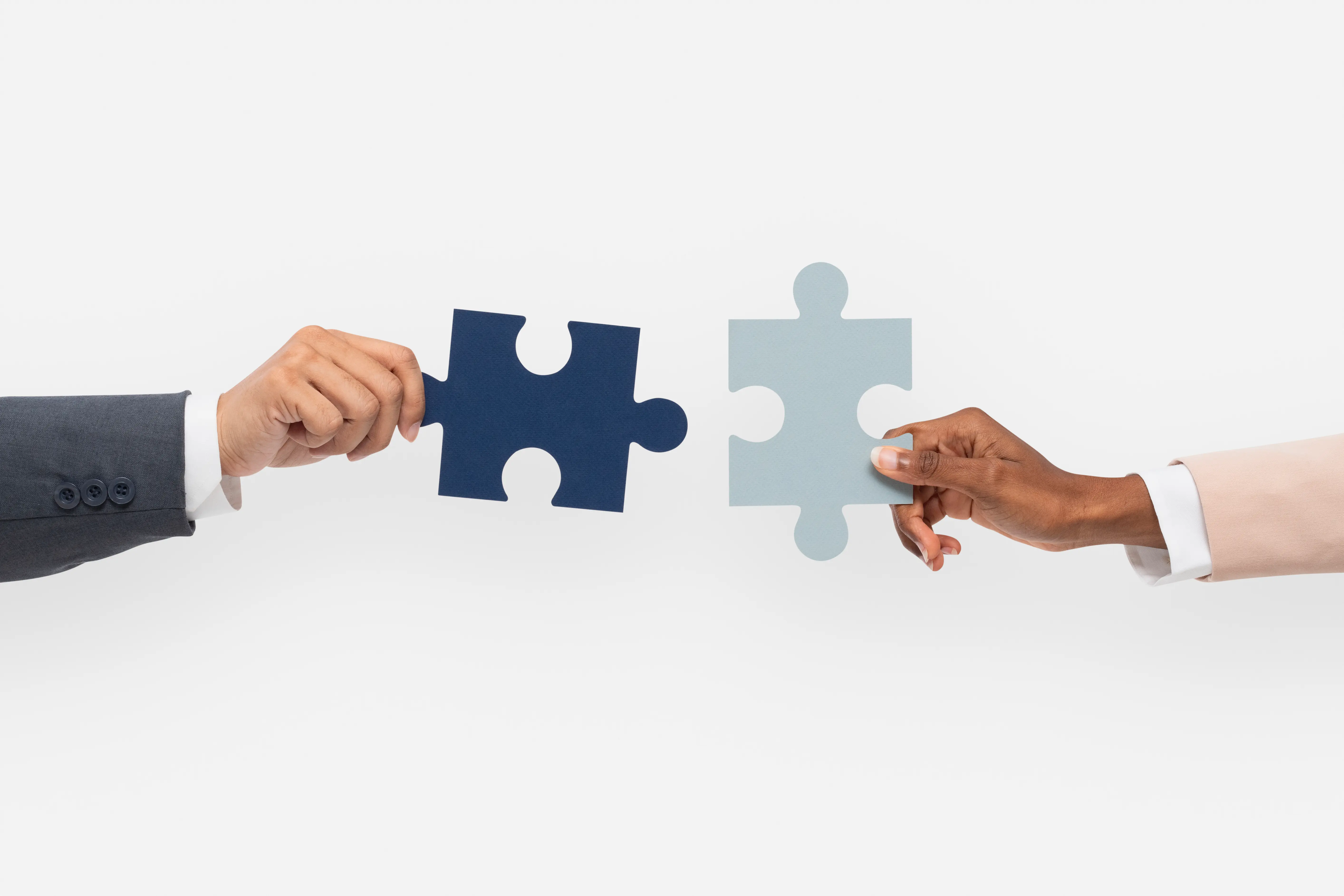 Deux professionnels réunissant des pièces de puzzle pour illustrer un partenariat
